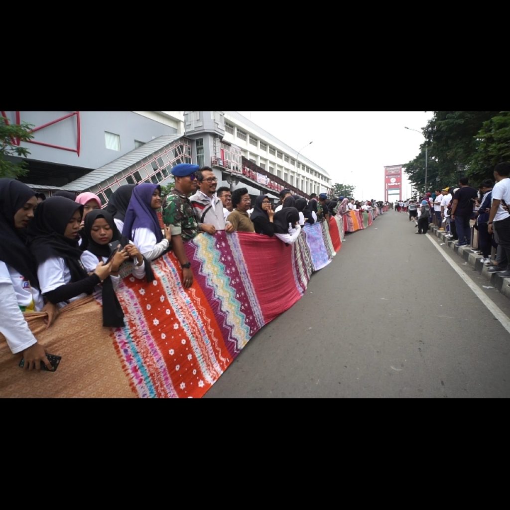 Jokowi Bentangankan Kain Jumputan Sepanjang 1,1 Kilometer di Atas Jembatan Ampera