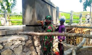 Personel Satgas TMMD Bersama Warga Plester Dinding Jembatan