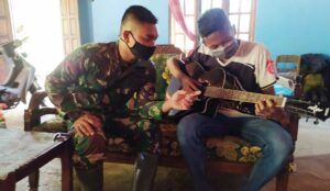 Satgas TMMD, Rileks Sejenak dengan Memainkan Gitar