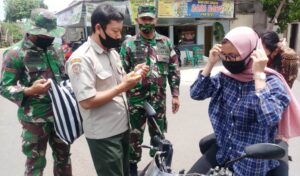 Putus Penyebaran Covid 19, Satgas TMMD Bagikan Masker Untuk Pengendara Motor