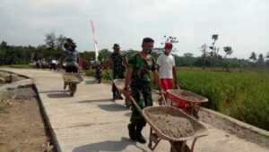 Satgas TMMD bersama Warga Tetap Pertahankan Semangat di Lokasi Pengecoran Jalan