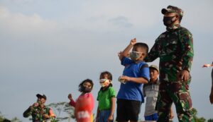 Keceriaan Anak-anak Saat Main Layang – Layang Bersama Anggota Satgas TMMD